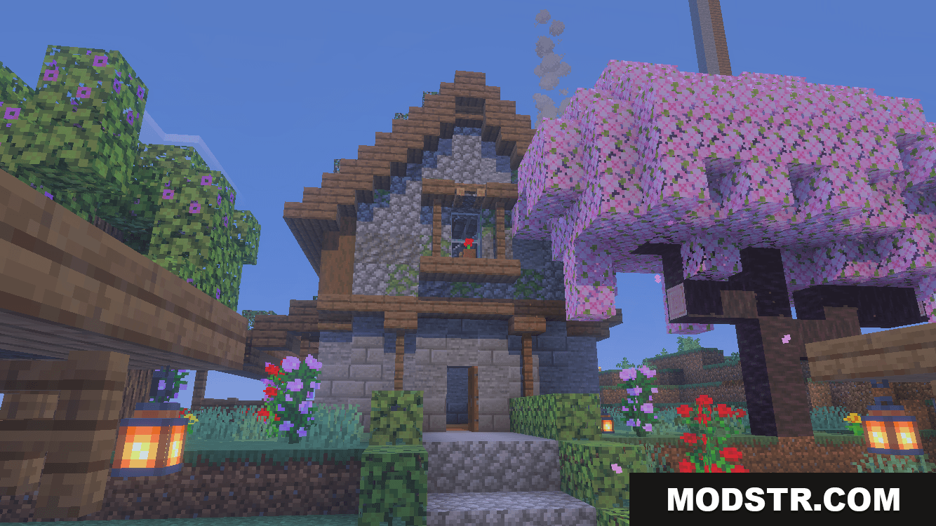 Large medieval stone house with a pink cherry blossom tree