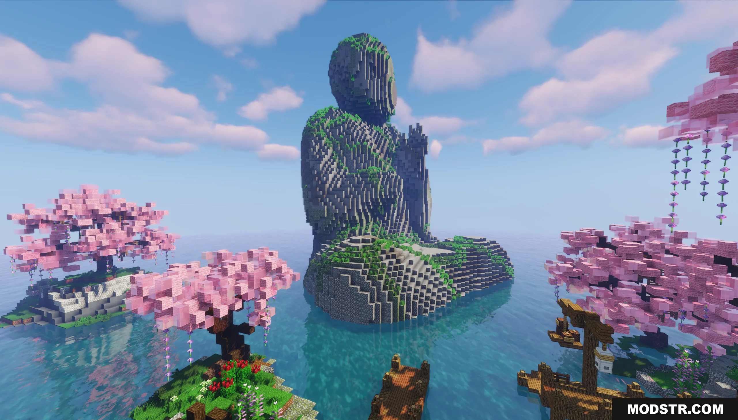Giant stone Buddha statue surrounded by pink cherry blossom trees in the ocean