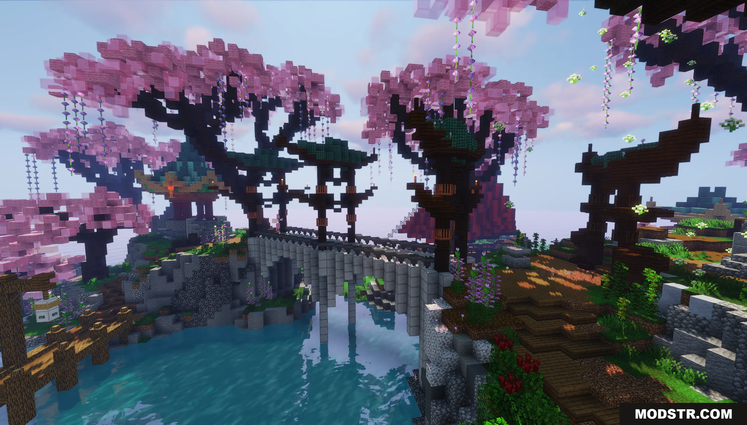 A stone bridge crosses water surrounded by pink trees and traditional architecture