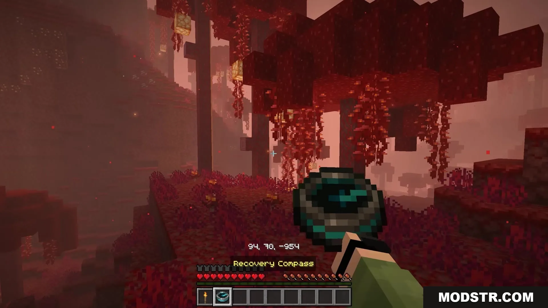Bits and Balance Mod Screenshot 7 A player holding a Recovery Compass while exploring the Crimson Forest biome