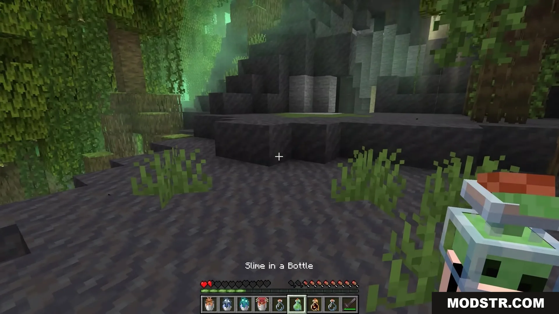Bucket Em Remodeled Resource Pack Screenshot 2 The player holds a captured slime inside a detailed 3D glass bottle