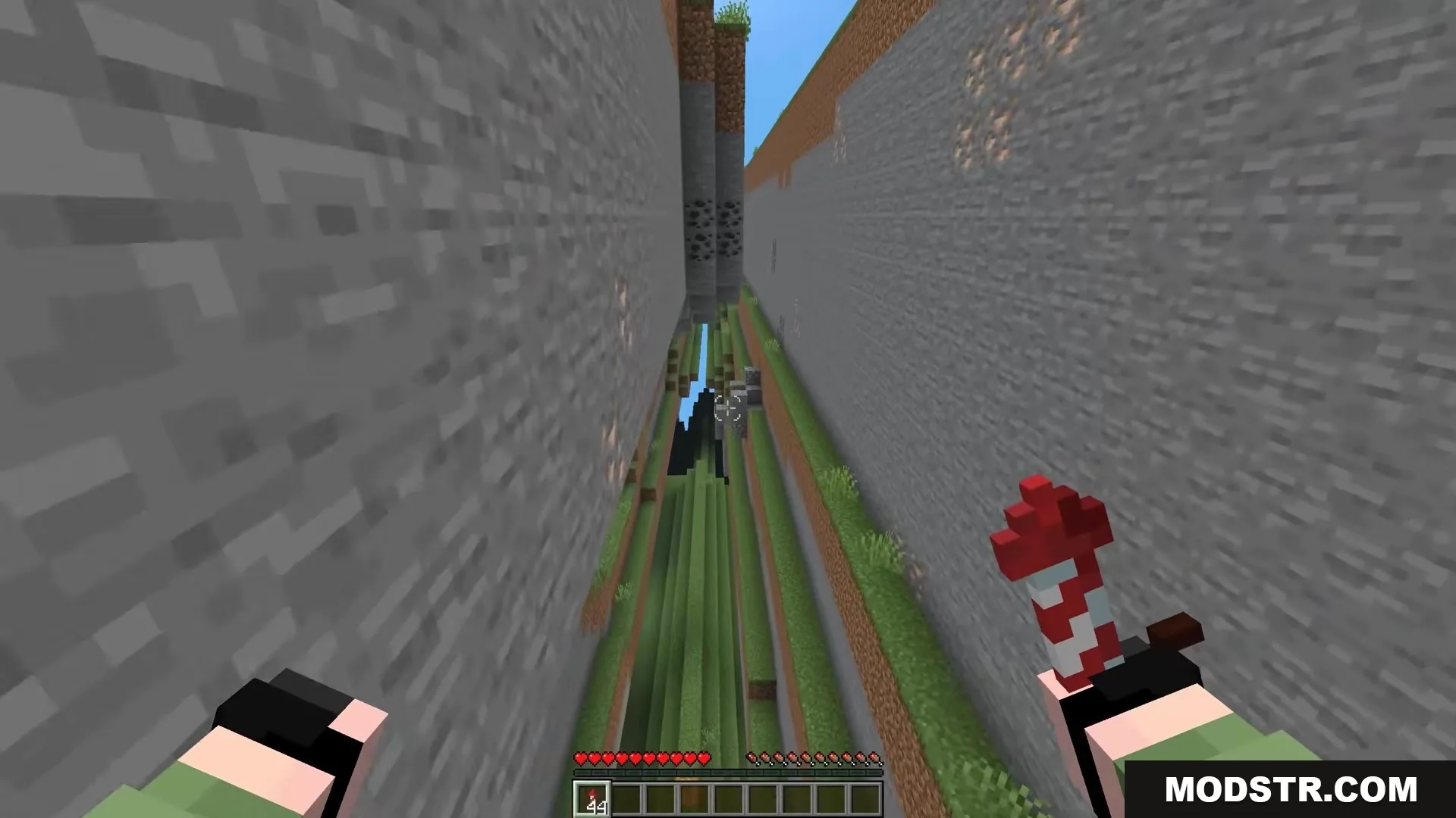 Player holding a firework rocket while flying through a deep vertical terrain gap