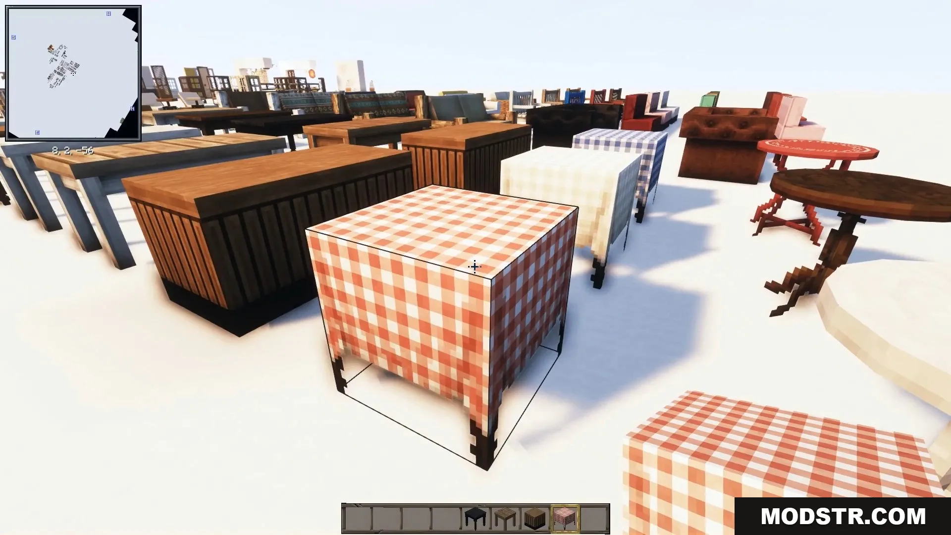 Wooden tables draped in red checkered tablecloths sit near comfortable armchairs.