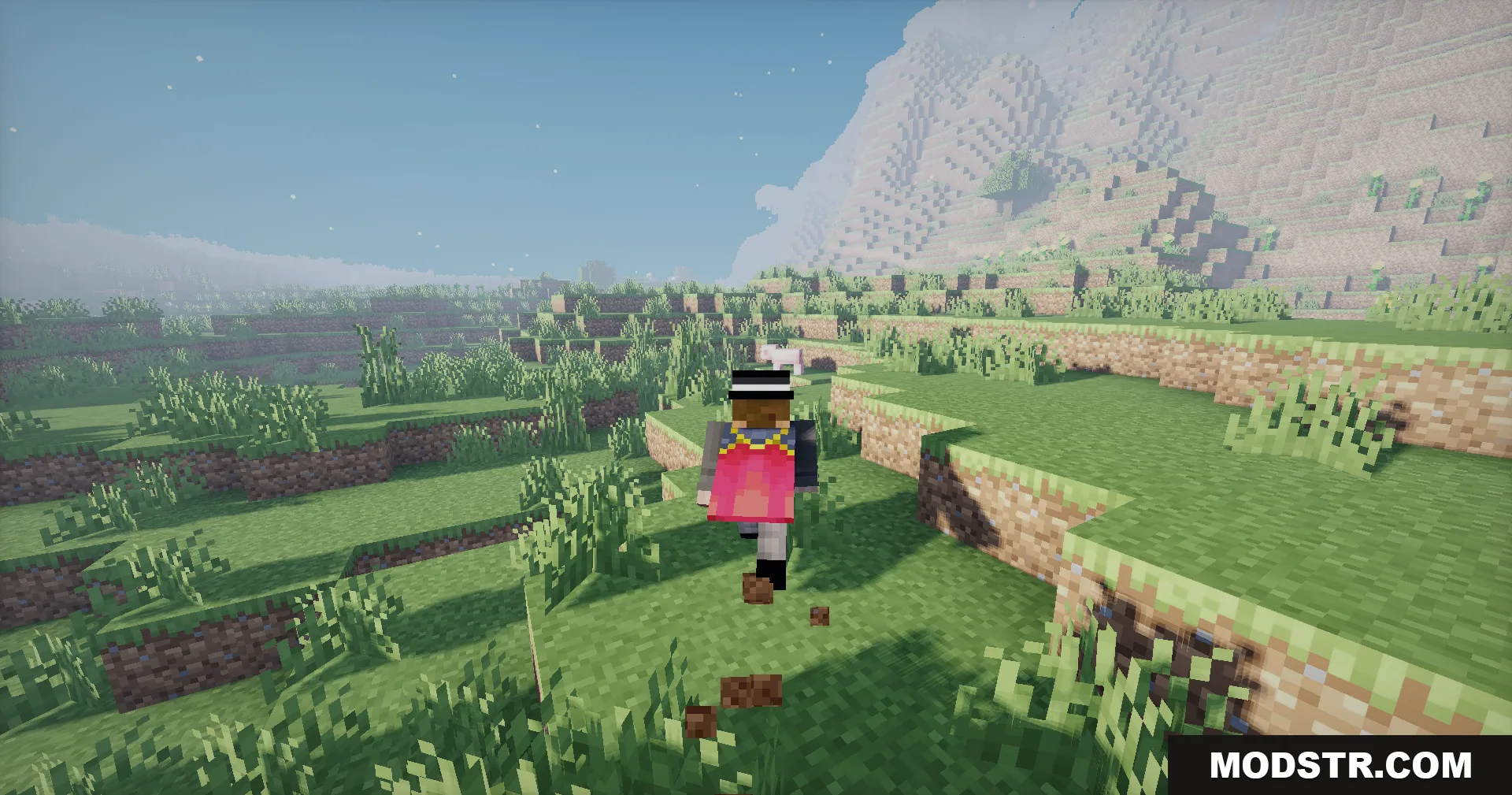 A player wearing a pink cape runs through a sunny grassy field near mountains