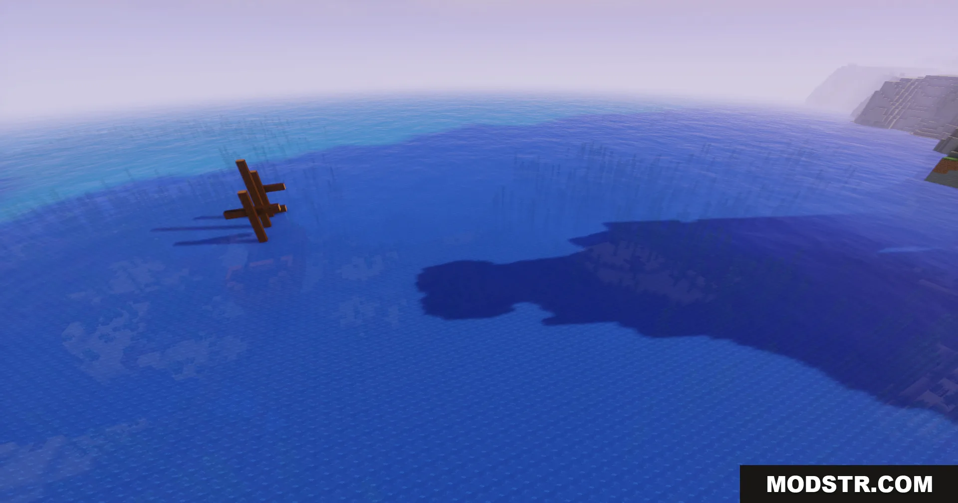 A wooden structure casting a long shadow on the vast blue ocean
