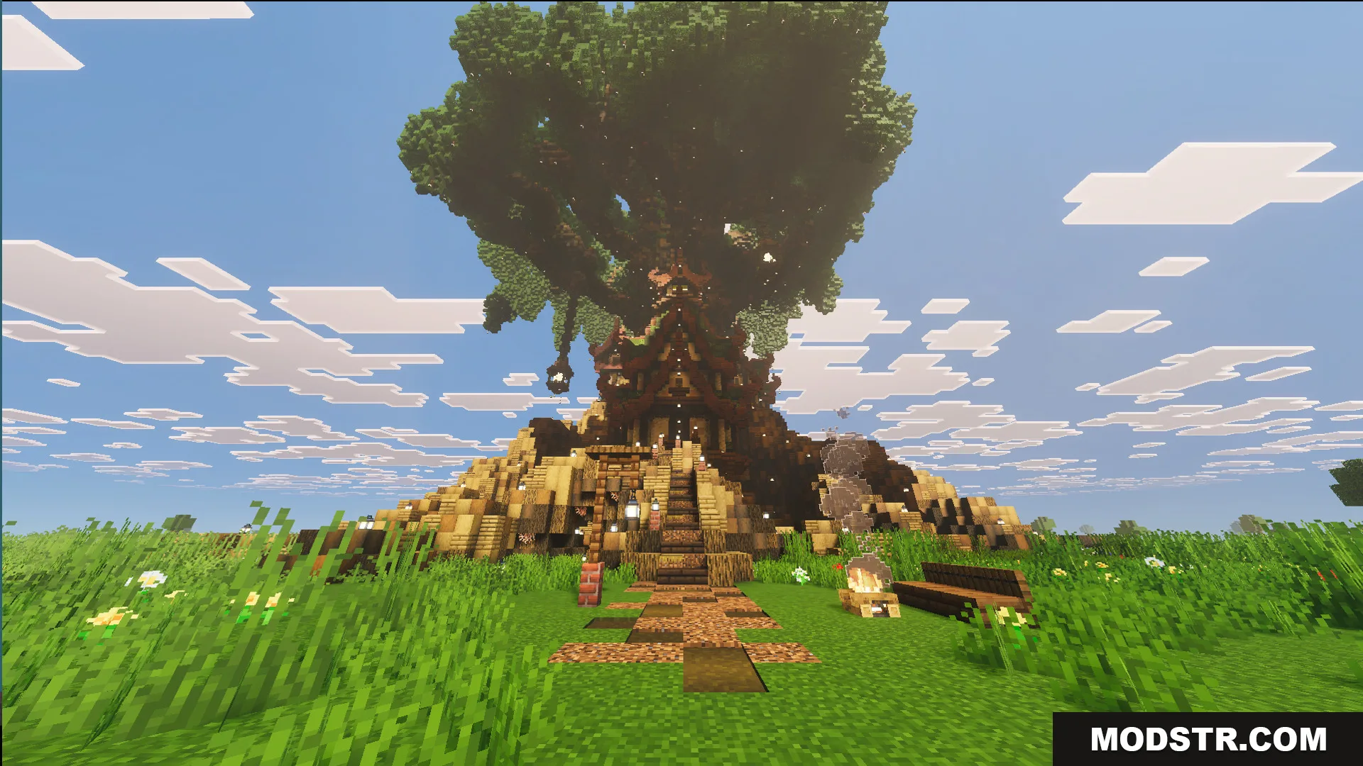 Giant oak tree with small red roofed houses and a dirt path