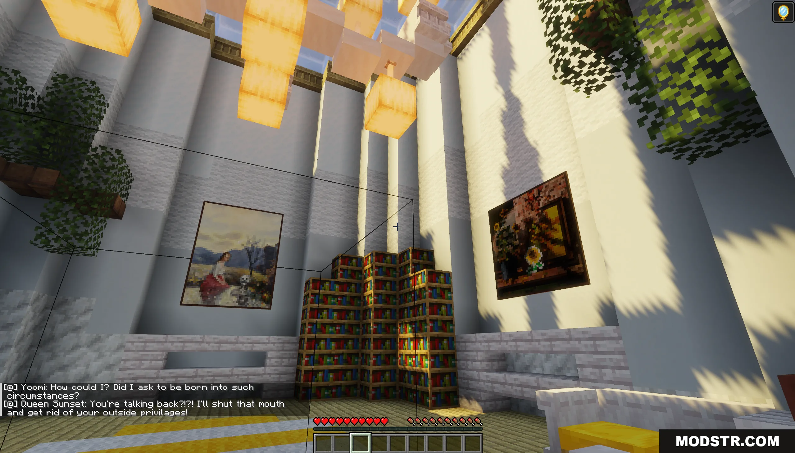 A tall library room with bookshelves and paintings under hanging glowstone lights