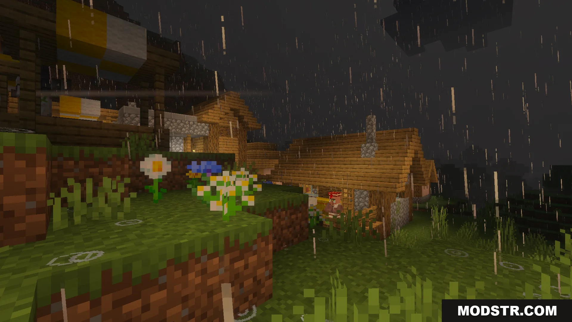 Wind driven rain falling over a village with wooden houses and flowers