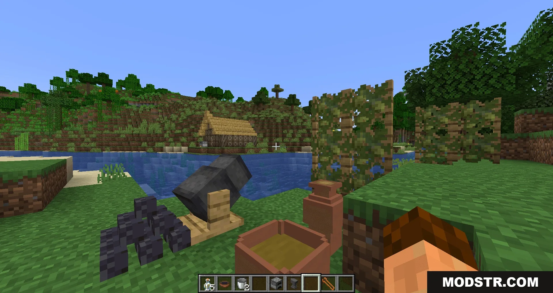 A primitive kiln and clay pots placed near a river bank