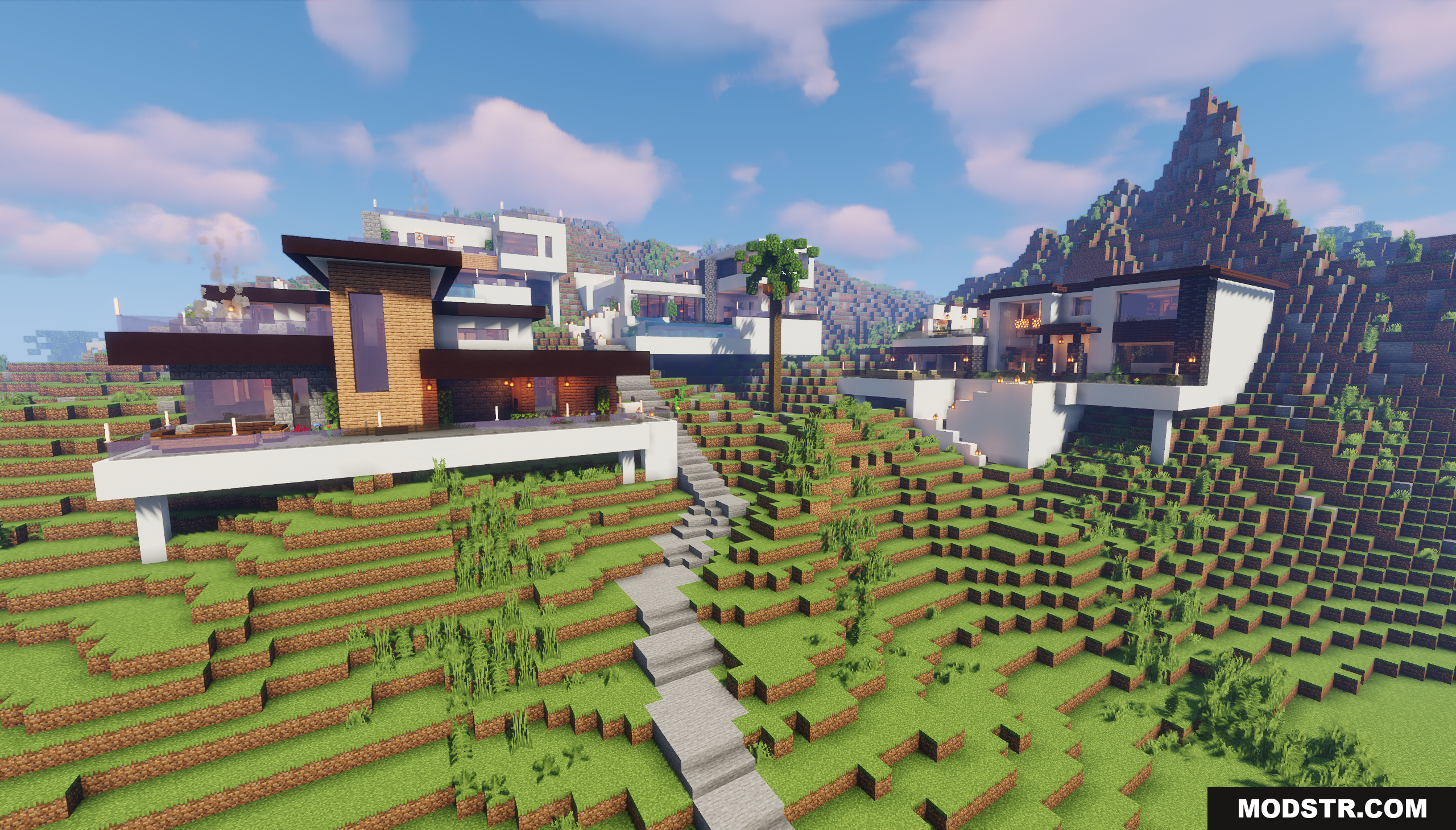 Modern houses built on a grassy hillside with stone stairs leading up