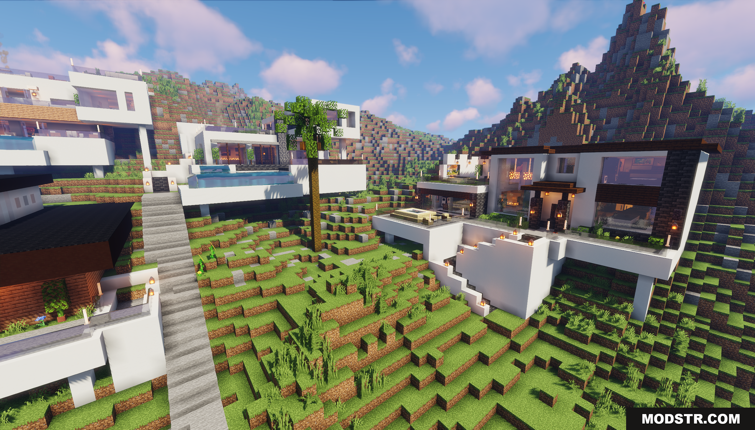 White modern houses on a grassy hill with long stone stairs