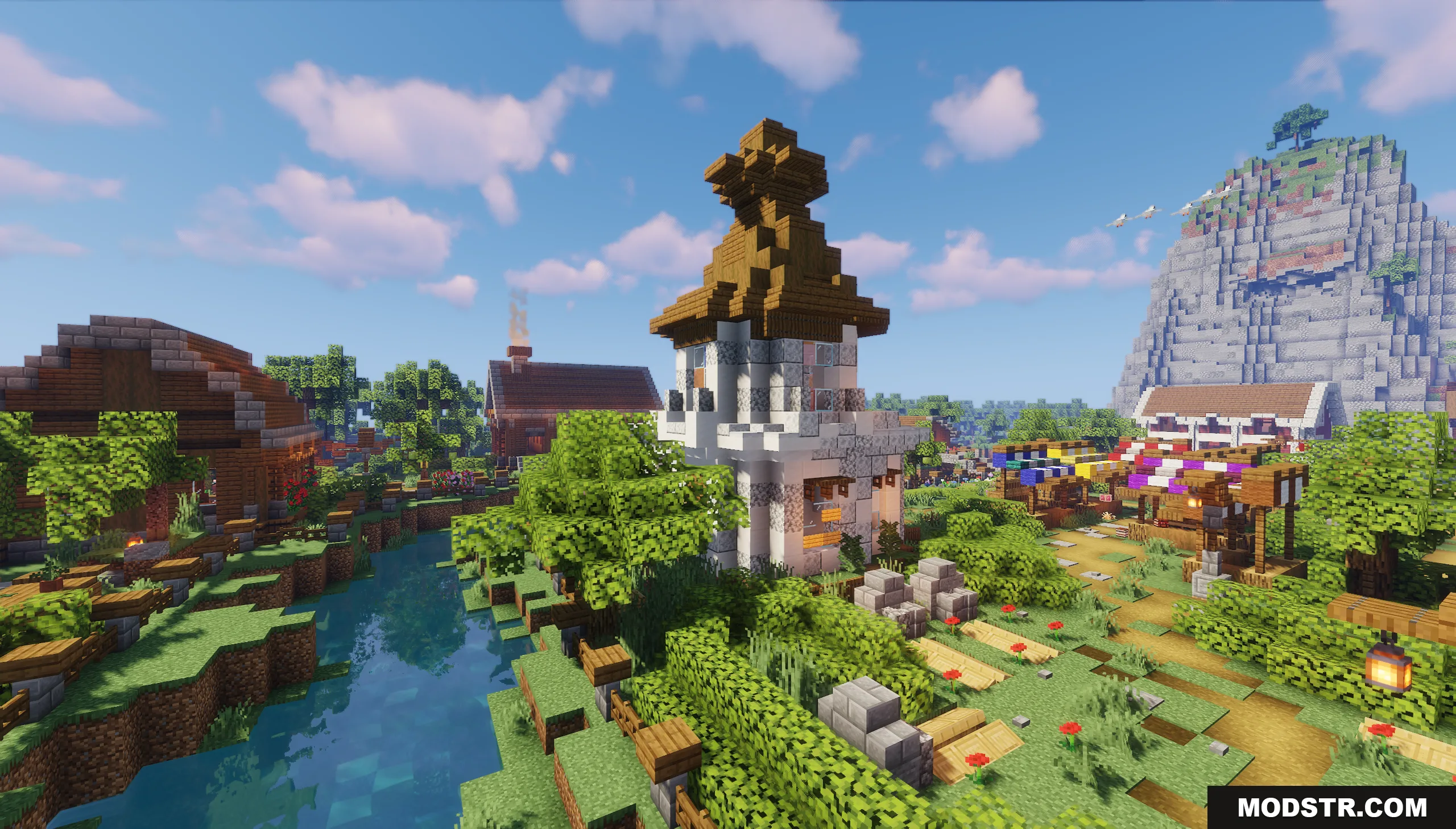 A tall white tower overlooks a river in a cozy Minecraft village