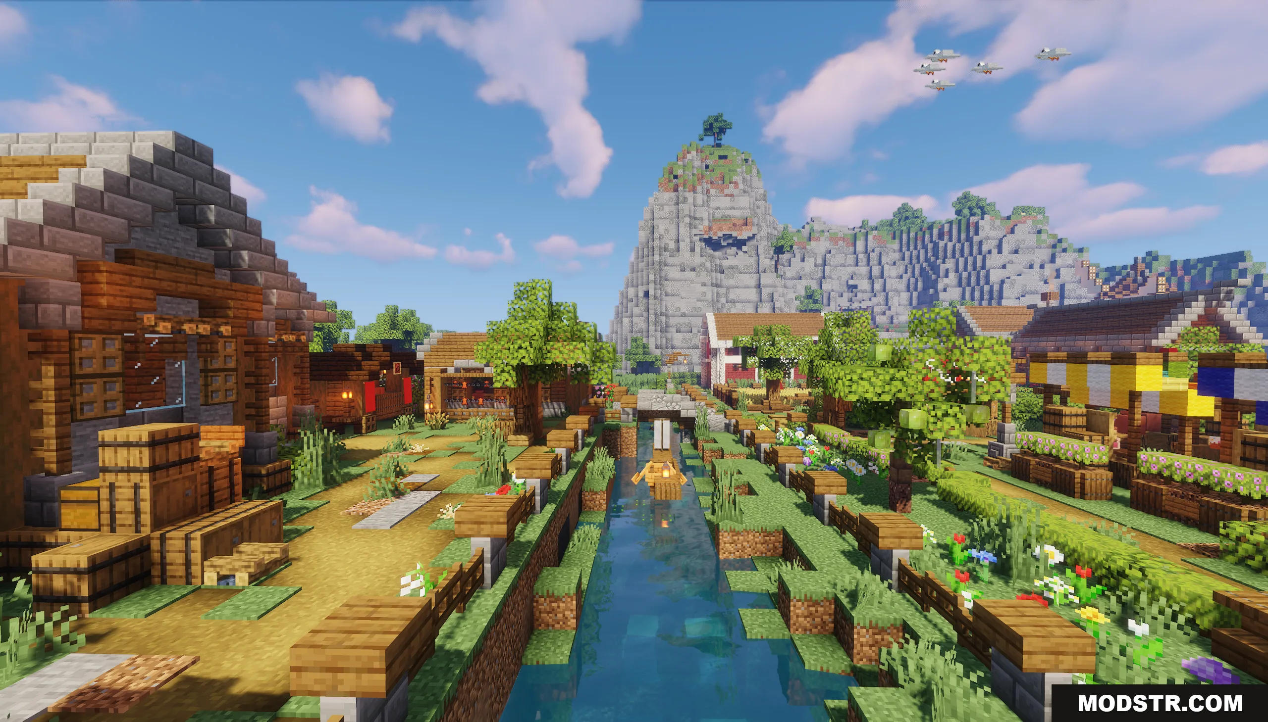 A scenic village canal with a small boat and a mountain background