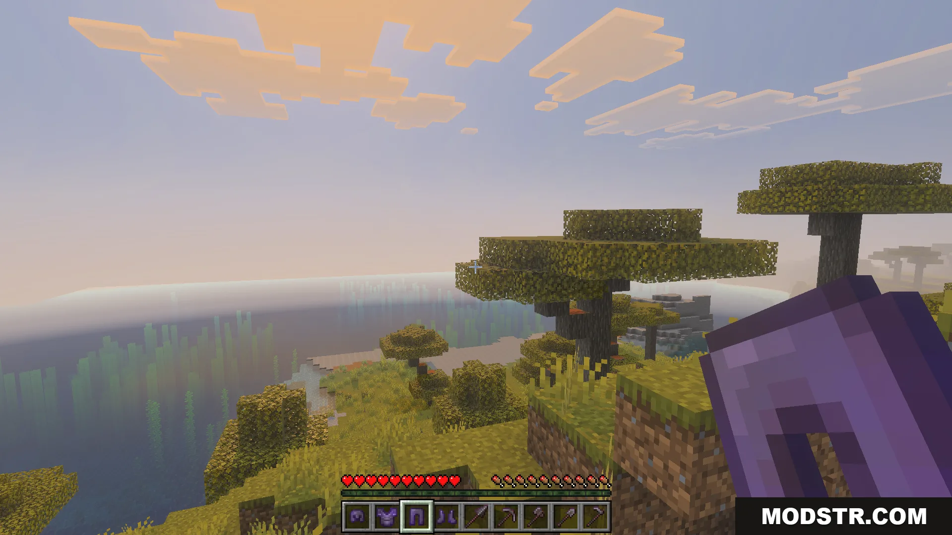 OP Loot Kit Addon Screenshot 4 First person view of a player holding netherite leggings in a savanna biome