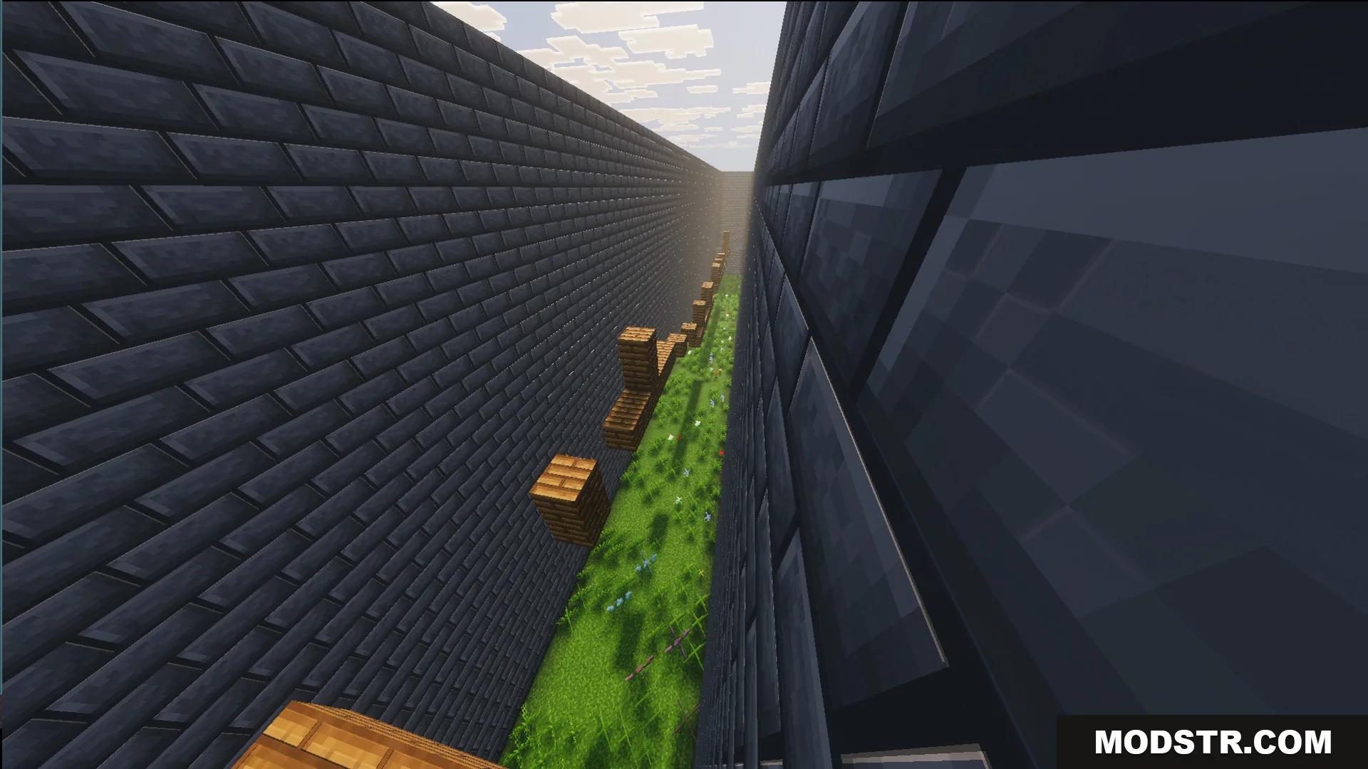 Easy parkour jumps inside a narrow stone brick corridor with grass below