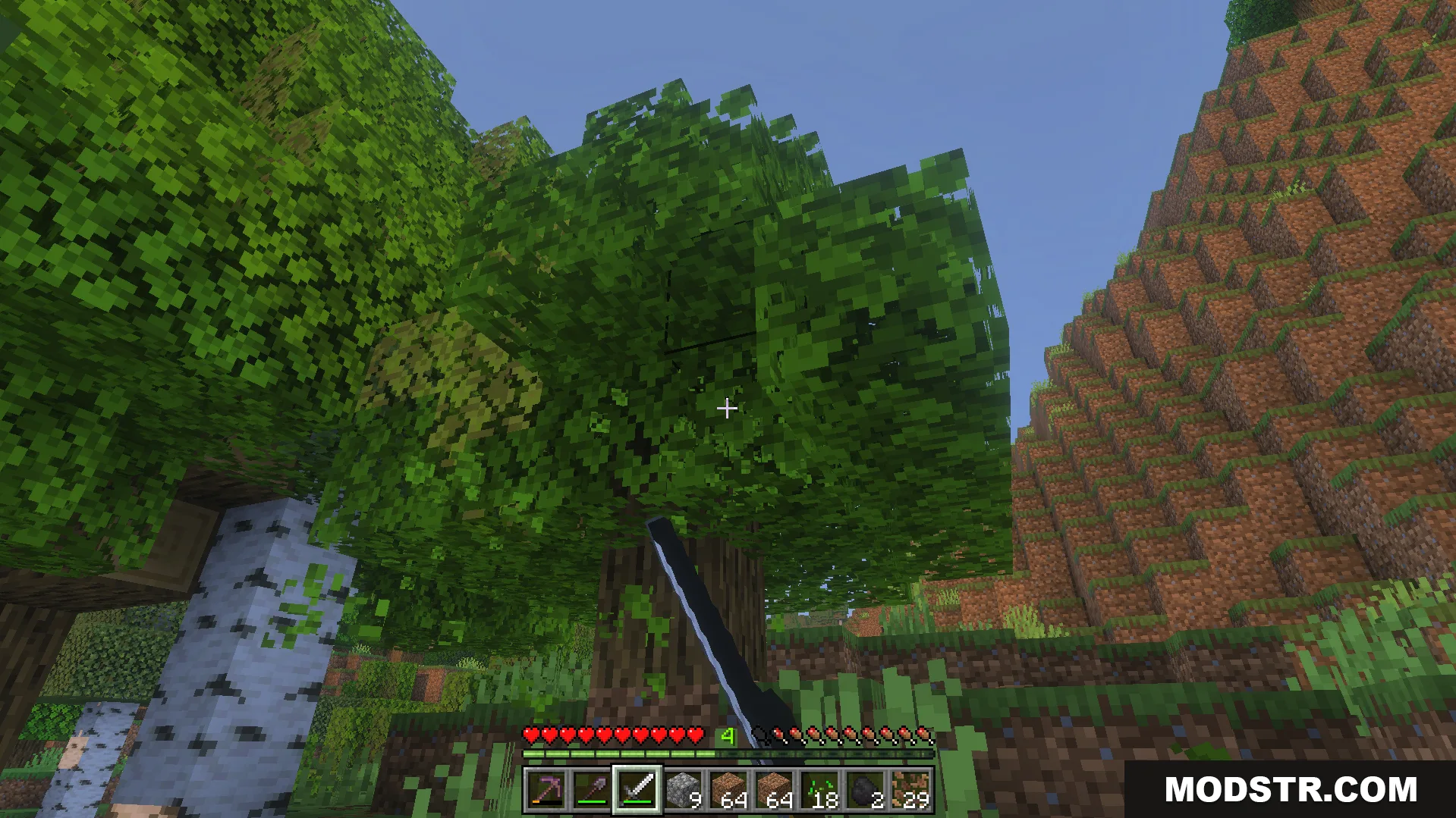 Player exploring a forest biome while holding a sword and gathering building materials