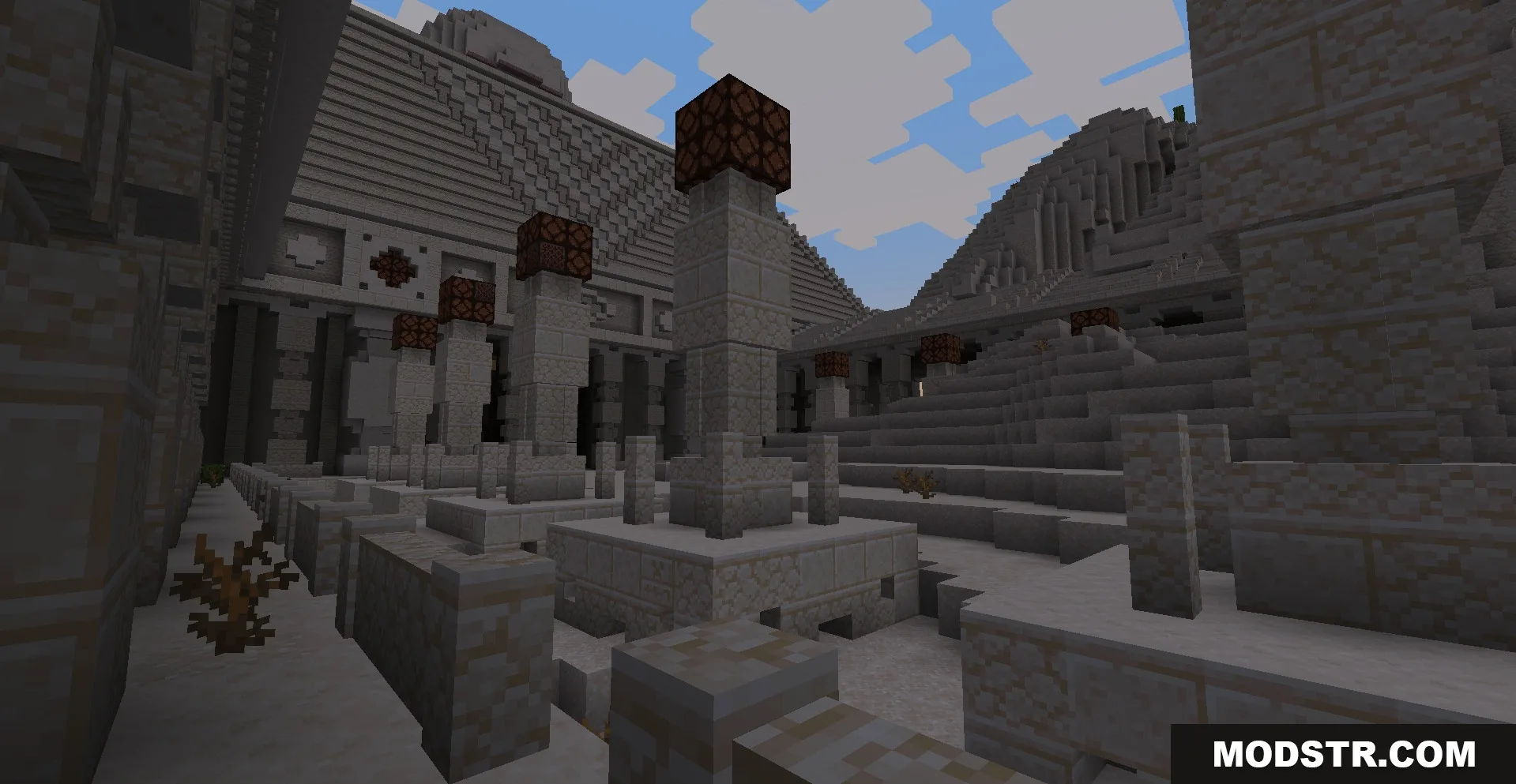 Exterior view of a large sandstone monument with pillars and redstone lamps