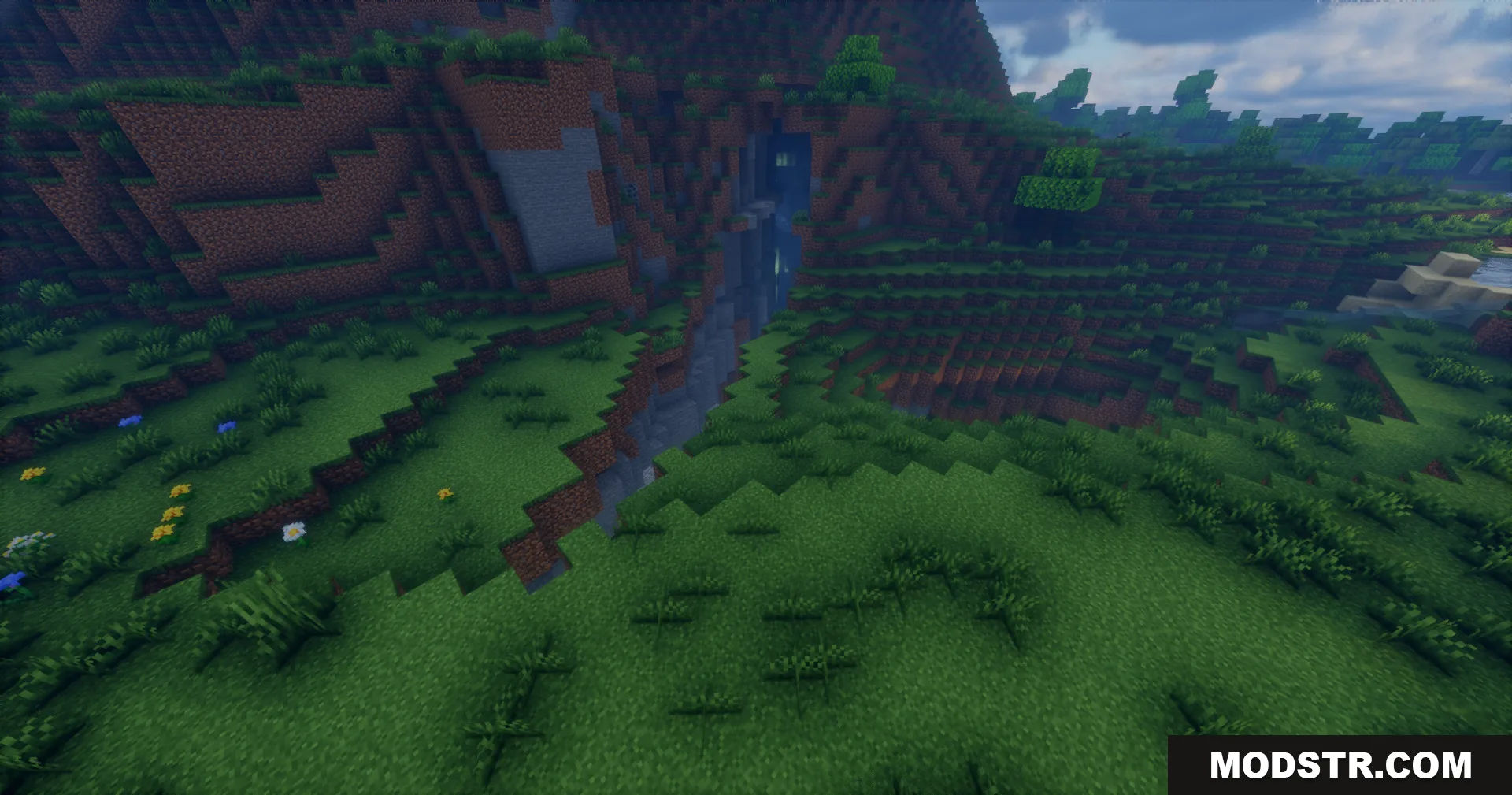 Rrtt217 S Hdr Mod Screenshot 14 Grassy terrain in Minecraft showing a small ravine with water and enhanced shadows