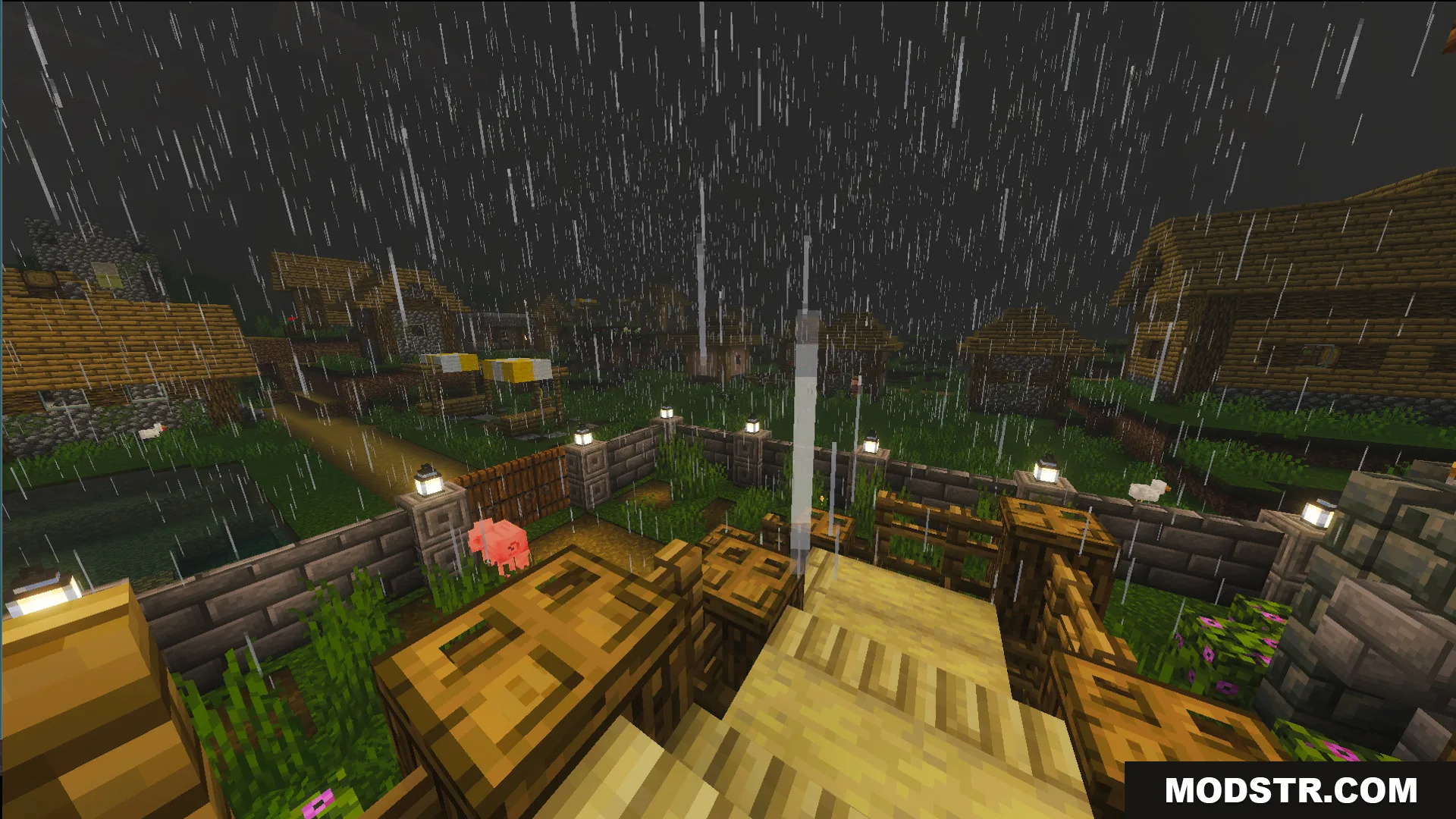 Rainy exterior view of a fenced farm and a village in the distance