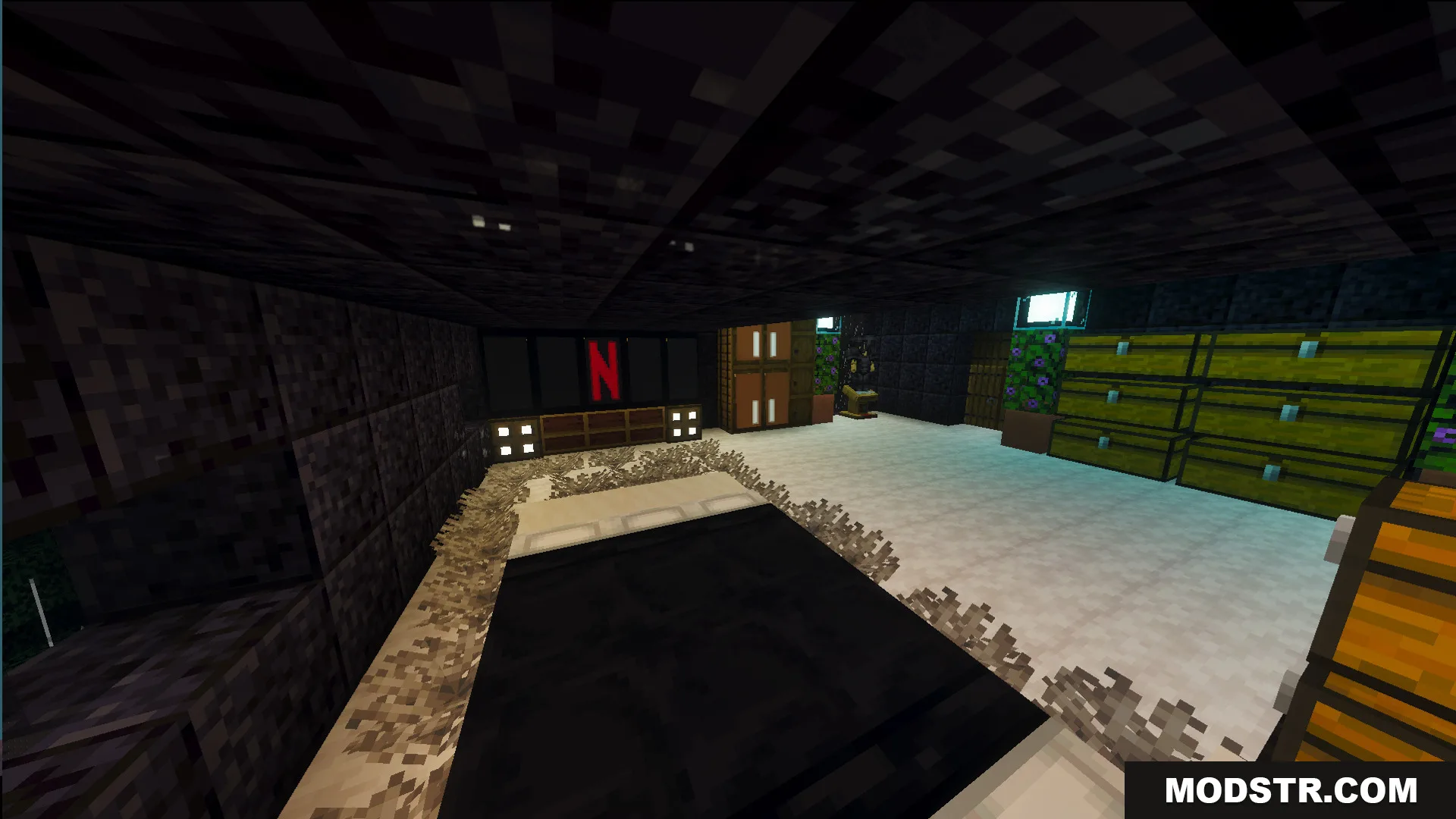 Modern interior of the survival house showing a bed and large television