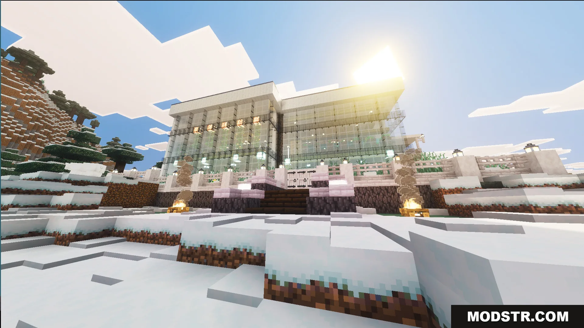 A large glass building with campfires located in a beautiful cold snowy landscape