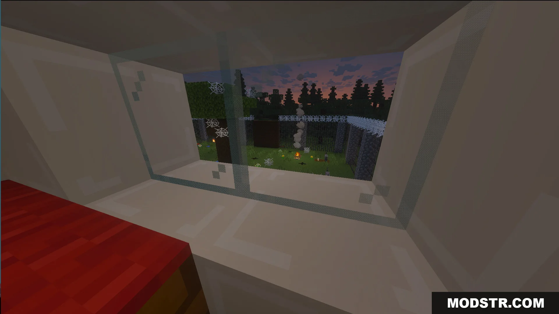 Looking through a window at a yard with cobwebs and a campfire