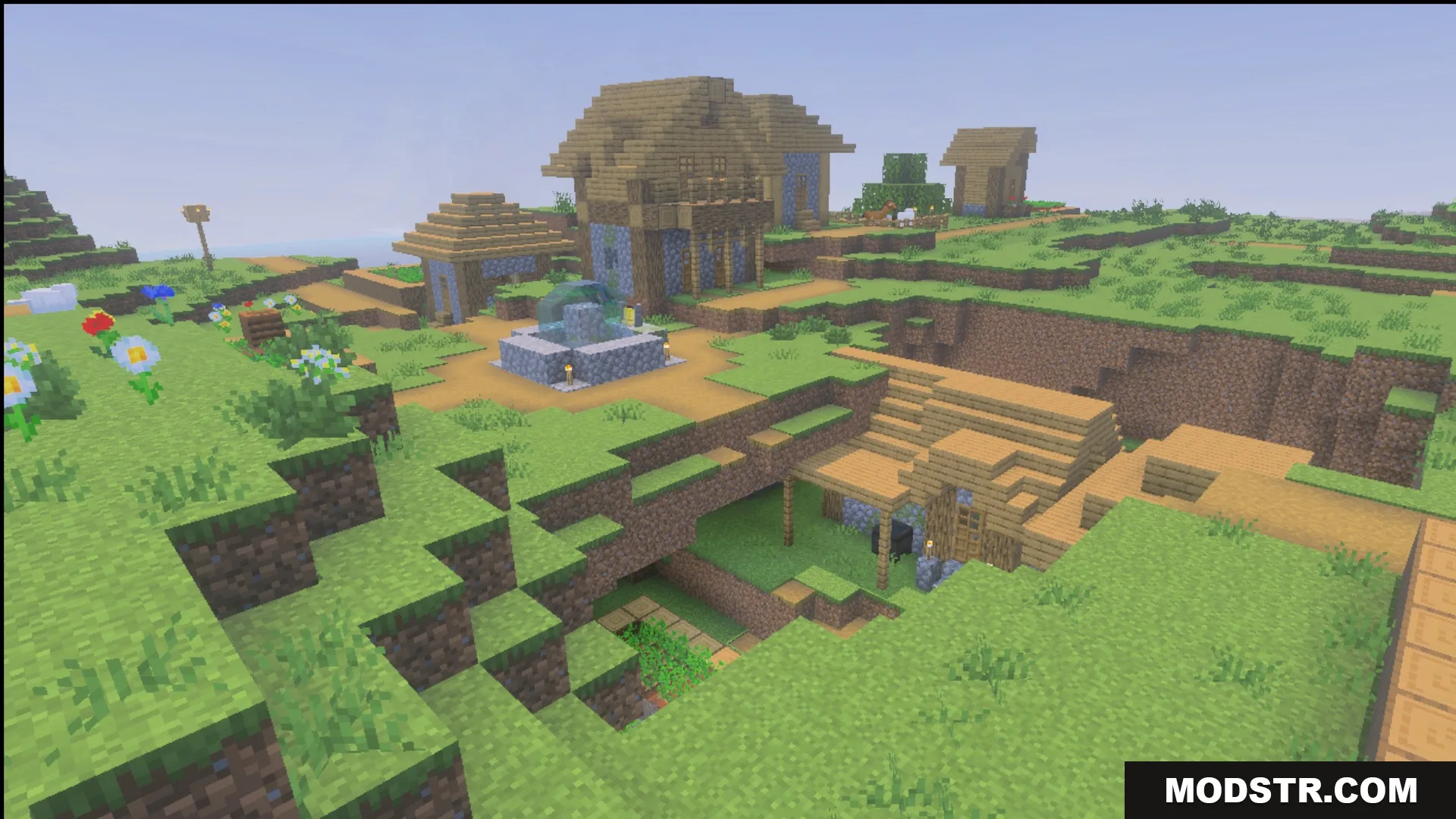 Village buildings and a fountain in daylight showing the Ultimate Survival block textures