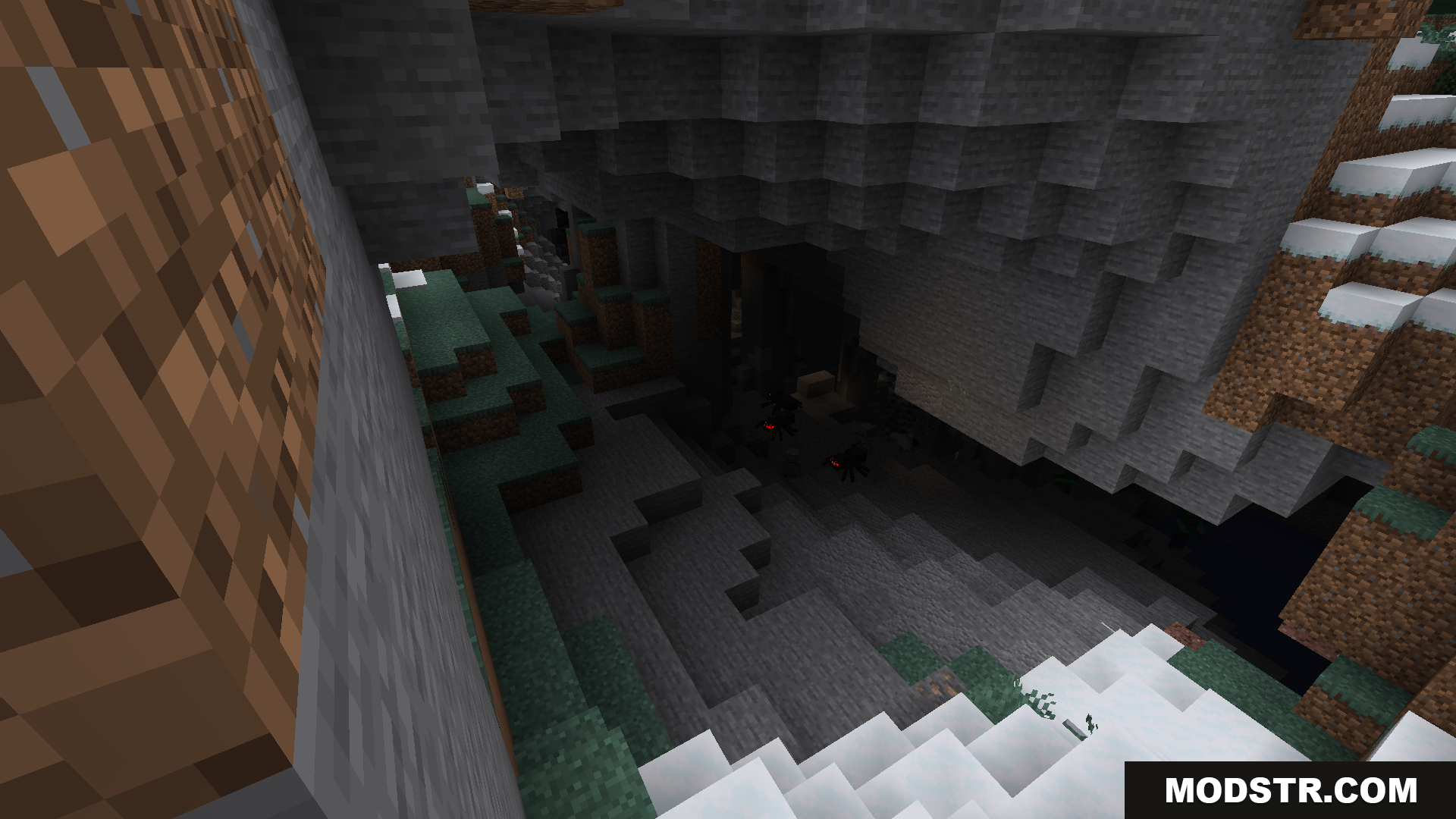 A dark cave entrance in a snowy, rocky mountain
